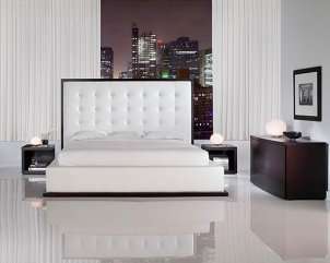 White leather luxury bed with bright city lights in the background